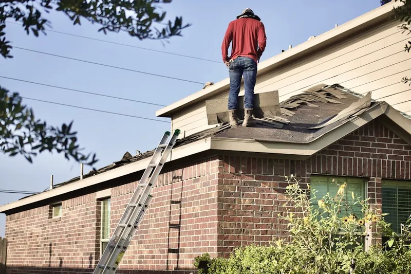Professional roofer working on a residential roof in Point Airy